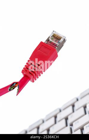 Defective network cable on keyboard, symbolic photo for online, networks, interference and espionage Austria Stock Photo
