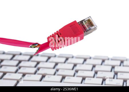 Defective network cable on keyboard, symbol photo for online, networks, malfunction and espionage Stock Photo