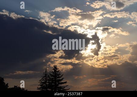 sun reappearing from behind heavy dark clouds Stock Photo