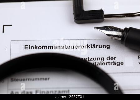 German annual income tax return declaration form blank on A4 tablet lies on office table with pen and magnifying glass close up. German annual income Stock Photo