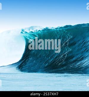 Big blue wave breaks in a blue ocean Stock Photo - Alamy