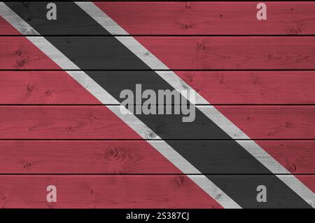 Trinidad and Tobago flag depicted in bright paint colors on old wooden wall close up. Textured banner on rough background. Trinidad and Tobago flag Stock Photo