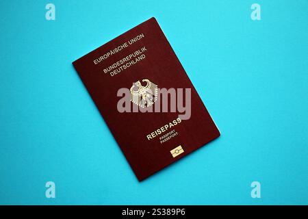 Red German passport of European Union on blue background close up. Tourism and citizenship concept. Red German passport of European Union on blue Stock Photo
