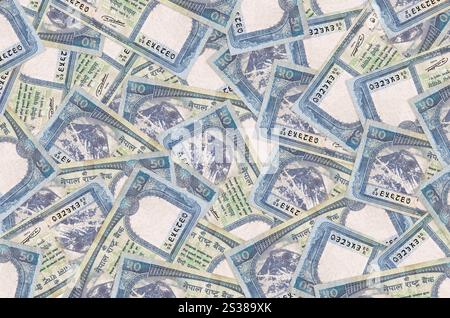 50 Nepalese rupees bills lies in big pile. Rich life conceptual background. Big amount of money Stock Photo