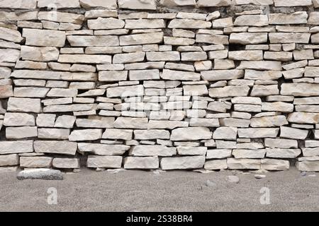 Texture of a stone wall background. Part of a stone fortress or castle fencing for background. Texture of a stone wall background from small stones Stock Photo