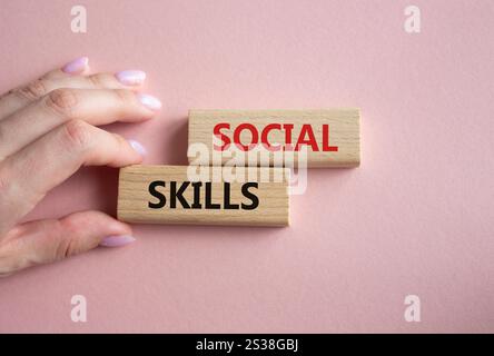 Social skills symbol. Wooden blocks with words Social skills Beautiful pink background. Businessman hand. Business and Social skills concept. Copy spa Stock Photo