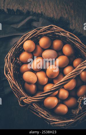 Organic brown eggs in a basket on wooden table Stock Photo