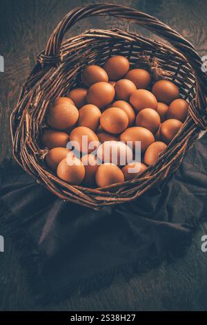 Organic brown eggs in a basket on wooden table Stock Photo