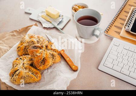 Lunch in a office, delicious bread rolls with butter and coffee on desktop Stock Photo