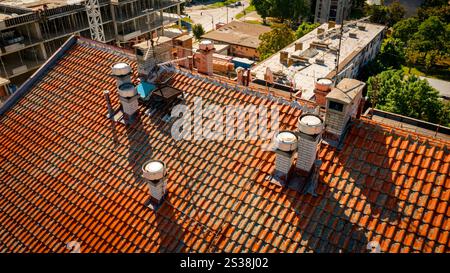 Above view on roof of old multistory building, with ventilation system, chimney made of bricks, architecture. Stock Photo