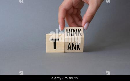 Think Tank symbol. Businessman hand Turnes cubes with words Think Tank. Beautiful grey background. Business and Think Tank concept. Copy space Stock Photo
