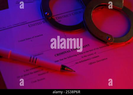 District Court Criminal complaint court papers with handcuffs and blue pen on table close up Stock Photo