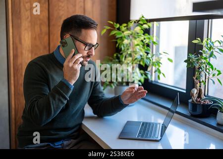 Young male employee, business man working in the office or remote work at home Stock Photo
