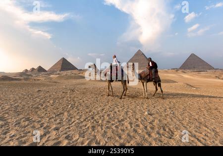 Great Pyramids of Giza - couple riding camels on the desert Stock Photo