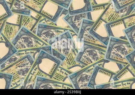 50 Nepalese rupees bills lies in big pile. Rich life conceptual background. Big amount of money Stock Photo