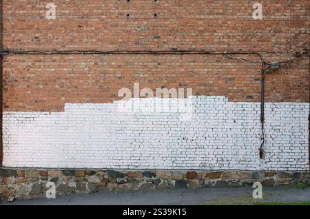 Residental house wall with white paint patches covering graffiti vandalism on exterior Stock Photo