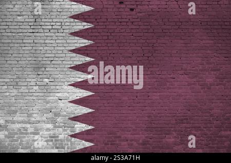 Qatar flag depicted in paint colors on old brick wall close up. Textured banner on big brick wall masonry background Stock Photo