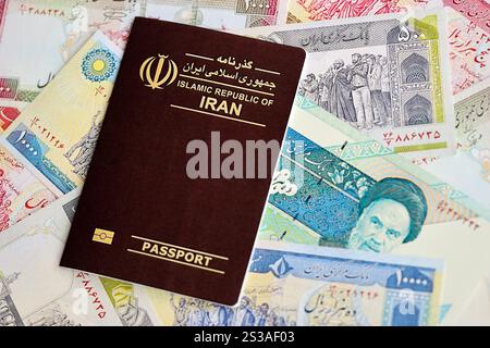 Red Islamic Republic of Iran passport and iranian reals money bills background close up. Tourism and travel concept Stock Photo