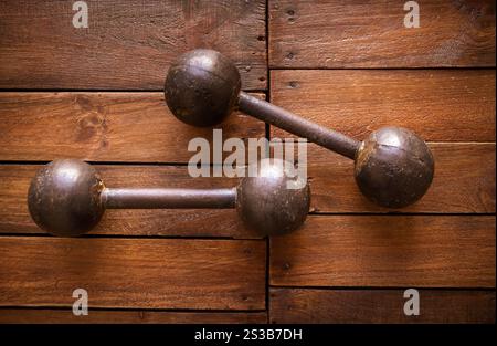 Old rusty dumbbells on rustic wood board background texture. Old rusty dumbbells on wood background texture Stock Photo