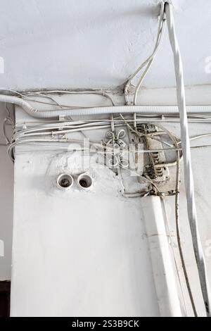 tangled electrical wiring in hall of residential building Stock Photo