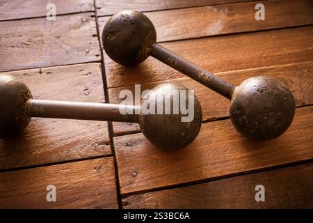 Old rusty dumbbells on rustic wood board background texture. Old rusty dumbbells on wood background texture Stock Photo