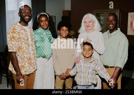 Portrait of beaming biracial family standing in living room of huge cottage and posing together Stock Photo