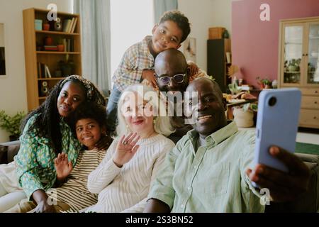 African American man holding smartphone while taking selfie with his beloved family Stock Photo