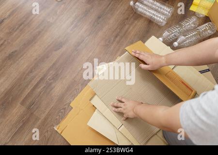 Home recycle eco zero waste concept Man using recycle paper box. Stacking brown cardboard box eco friendly packaging made of recyclable raw materials Stock Photo