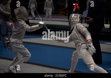 Two fencing champions clash in an intense tournament match, showcasing their skill and precision in this thrilling sport Stock Photo