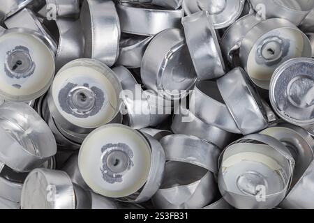 A lot of empty aluminum cups from burnt tea lights candles. Background, close-up. Stock Photo