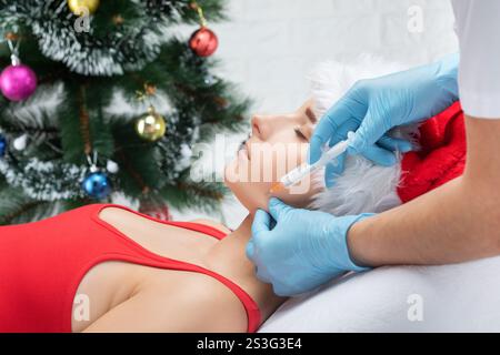 Cosmetologist makes rejuvenating anti wrinkle injections on the face of a beautiful woman. Female aesthetic cosmetology in a beauty salon. Stock Photo