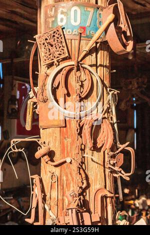 A pole is covered in various rusty objects, including a license plate with the number 6078 Stock Photo
