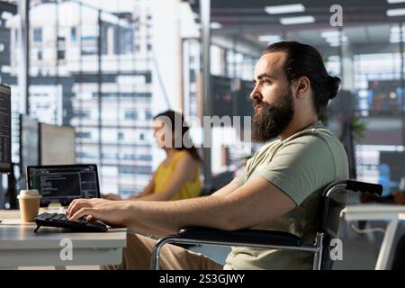 Admin with disability in inclusive workspace utilizing cloud computing resources and platforms to train machine learning models. Person with paraplegia monitoring and maintaining company systems Stock Photo