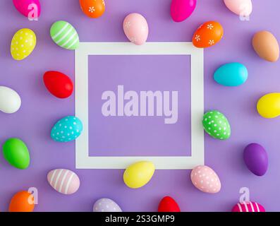 Spring pattern made of colorful Easter eggs on purple background with copy space. Minimal Easter concept. Creative festive holiday layout. Stock Photo