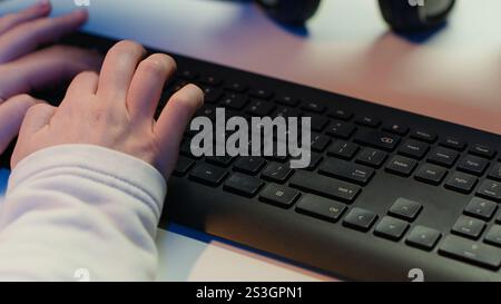 Computer technician working from home, designing and developing software applications, close up. IT specialist typing on PC keyboard, implementing and maintaining company systems, camera A Stock Photo