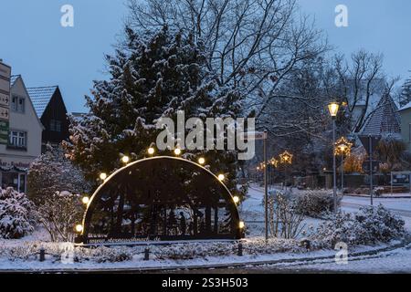 Candle arch on the main street, snow-covered and at dusk, in the background the old church, Coswig, Saxony, Germany, Europe Stock Photo