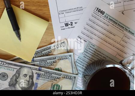 IRS 1040 and W-2 tax forms, close up, top down view of tabletop with coffee cup Stock Photo