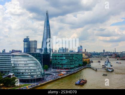 Stunning view of The Shard & City Hall along the River Thames,captured from Tower Bridge, w/London’s iconic skyline framed by fluffy clouds & blue sky Stock Photo