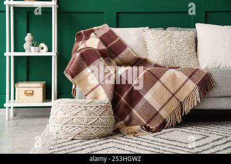 Interior of living room with sofa and knitted blanket Stock Photo