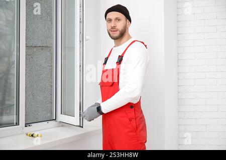 Male worker repairing window in room Stock Photo