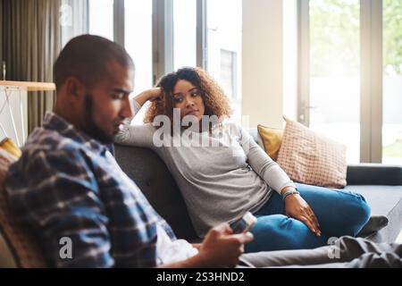 Couple, separation or fight with argument on sofa for disagreement, conflict or living room dispute at home. Upset woman, man or cheating affair with Stock Photo