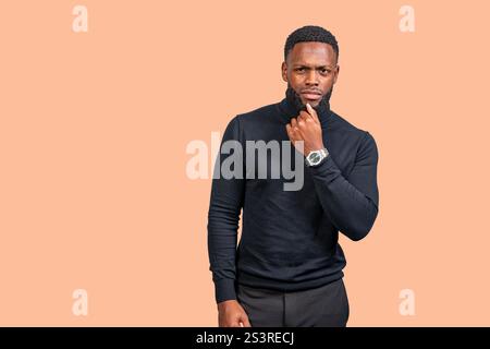 Studio portrait of a young african american businessman thinking with hand on chin Stock Photo