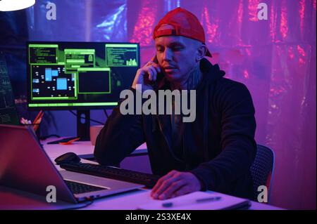 IT Worker Talking On Mobile Phone In Office Stock Photo