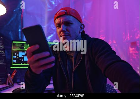 IT Worker Using His Smartphone At Work Stock Photo