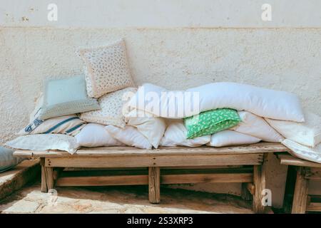 Cushions  of various shapes and colors placed on a chair outside to be aired. The chairs are made of wood. Atmospheric picture of northern Italy. Stock Photo