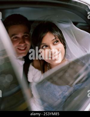 Bride and groom sitting inside a car Stock Photo