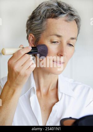 Woman Holding Compact Mirror Applying Blush Stock Photo