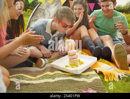 Teenage Boy Blowing out Birthday Candles Stock Photo