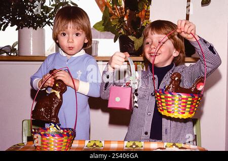 Portrait cute, happy boys with Easter baskets and chocolate bunnies Stock Photo