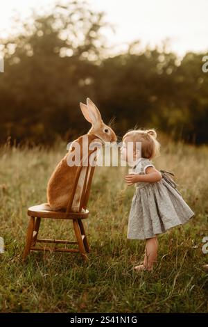 bunny kisses with toddler in field Stock Photo